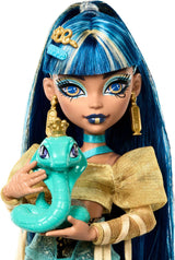 Monster High Cleo De Nile-Puppe in einer goldenen Bluse und einem mehrlagigen Rock, inklusive der Hissette-Kobra und Accessoires wie einer Schultasche, einem Snack und einer Rolle Toilettenpapier, HXH74